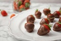 Plate with chocolate covered strawberries on table Royalty Free Stock Photo