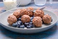 A plate of chocolate nut clusters with blueberries and cream in the background Royalty Free Stock Photo