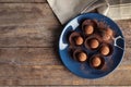 Plate with chocolate truffles on wooden background, top view. Royalty Free Stock Photo