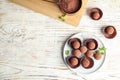 Plate with chocolate truffles on wooden background, top view. Royalty Free Stock Photo