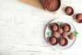 Plate with chocolate truffles on wooden background, top view. Royalty Free Stock Photo