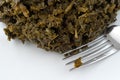 Plate of chopped kale with a fork close view