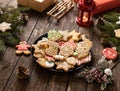 A plate with Christmas cookies having sugar glazing in holiday motives over them, traditional sweets and treats in Christmas