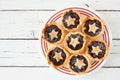 Plate of Christmas mincemeat tarts over a white wood background