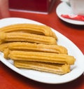 A plate with churros with sugar on top