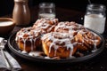 plate of cinnamon buns, dusted with powdered sugar and drizzled with sticky icing