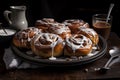 plate of cinnamon buns, dusted with powdered sugar and drizzled with sticky icing