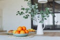 Plate with citrus fruits standing on wooden table in the kitchen