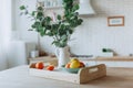 Plate with citrus fruits standing on wooden table in the kitchen