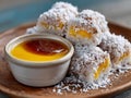A plate of coconut balls with a bowl of honey and a small bowl of coconut sauce Royalty Free Stock Photo