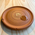 Plate with concentric circular patterns resting on a light wood Royalty Free Stock Photo