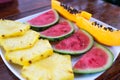 Plate containing pieces of fruit, papaya, watermelon and pineapple