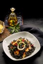 Plate of cooked arroz negro with oil on table