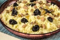 Plate with cooked couscous with almond, raisins and prunes