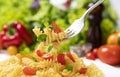 Plate of cooked italian fusilli pasta with tomatoes and basil leaves Royalty Free Stock Photo