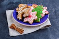 Plate with cookies on a napkin with cinnamon on a stone background