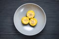 Plate of corn on a black wooden background with lots of fresh vegetables