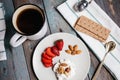 Top view A plate with cottage cheese, strawberries and nuts, a cup of coffee and towels on a wooden table Royalty Free Stock Photo