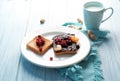 Plate with creative sweet toasts and cup of milk on table