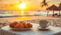 A plate of croissants and a cup of coffee on a table by the beach Royalty Free Stock Photo