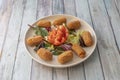 plate of croquettes stuffed with fried chicken with bÃÂ©chamel sauce with sprouts and tomato salad