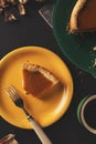 On a plate, crumbs and a fork on a dark background. a slice of pumpkin pie on a yellow plate while eating. Royalty Free Stock Photo