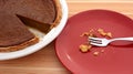Plate with crumbs next to a sliced pumpkin pie Royalty Free Stock Photo