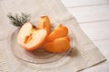 Plate with cut ripe persimmon on white wooden table