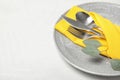 Plate with cutlery and napkin on light table, closeup. Royalty Free Stock Photo