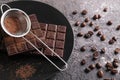 Plate with dark chocolate and sieve on grey background Royalty Free Stock Photo