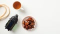 Plate of dates, arabic lantern, cup of tea, rosary on a white background. Ramadan Islamic holiday concept Royalty Free Stock Photo