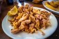 Plate of deep fried squids or Chipirones with lemon. Typical spanish tapa