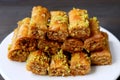 Plate of Delectable Baklava Pastries Topped with Chopped Pistachio Nuts on Black Table Royalty Free Stock Photo