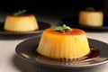 Plate of delicious caramel pudding with coffee beans and mint on white wooden table, closeup Royalty Free Stock Photo