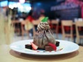 A plate of delicious chocolate crepe with vanilla ice cream inside, decorated with fresh strawberry and brownie. Royalty Free Stock Photo