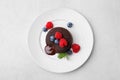 Plate with delicious chocolate fondant, berries and mint on light grey table, top view Royalty Free Stock Photo