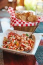 Plate of delicious colorful shrimp Ceviche and basket of tortilla chips on restaurant table