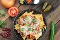 A plate of delicious corn chips nachos in cheddar cheese with beans, tomato, green chili, black olives, cilantro served with guaca Royalty Free Stock Photo