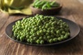 Plate with delicious fresh green peas on wooden table Royalty Free Stock Photo