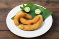 Plate with delicious fried bananas, lime and mint leaves on wooden table Royalty Free Stock Photo
