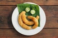 Plate with delicious fried bananas, lime and mint leaves on wooden table, top view Royalty Free Stock Photo