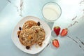 Plate with delicious oatmeal cookies, glass of milk and fresh strawberry on table Royalty Free Stock Photo