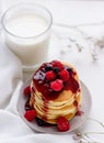 Plate with delicious pancakes with raspberries and berry sauce on white background
