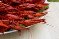 Plate with delicious red boiled crayfish on white wooden table, closeup Royalty Free Stock Photo