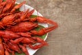 Plate with delicious red boiled crayfish on wooden table, top view Royalty Free Stock Photo