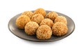 Plate of delicious sesame balls on white background