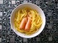 Plate with delicious spaghetti and two juicy sausages