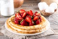 Plate of delicious thin pancakes with berries on table