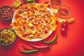 A plate of delicious tortilla nachos with melted cheese sauce, grilled chicken