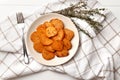 Plate with deliciously cooked sweet potatoes, rosemary, sauce and spices, herbs on a wooden Royalty Free Stock Photo